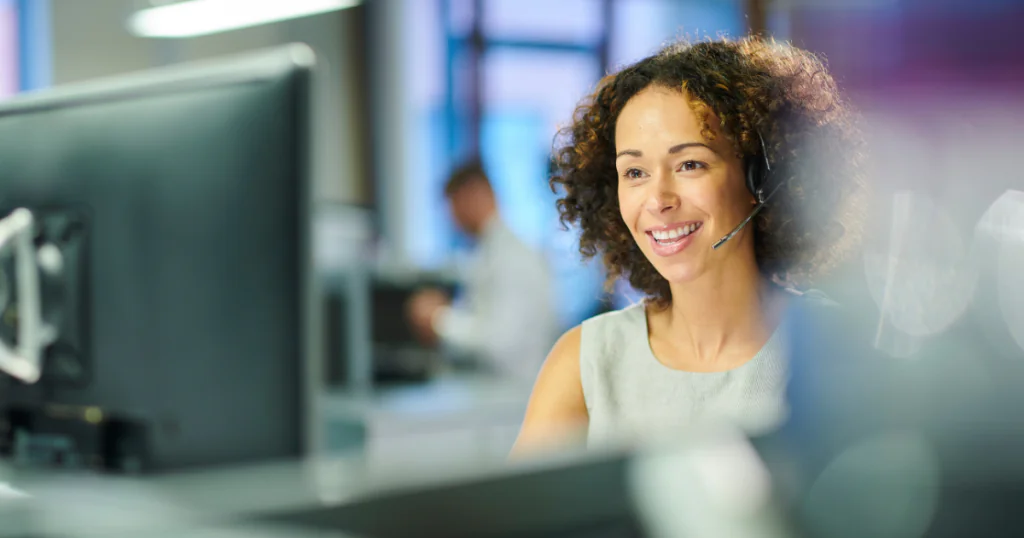 mulher sorrindo em frente a um computador. leis para ouvidorias.